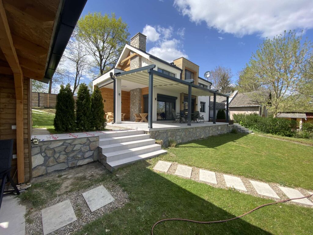 Uređenje okućnice uz kuću s travnjakom, vrtnim stazama i prostorom za boravak